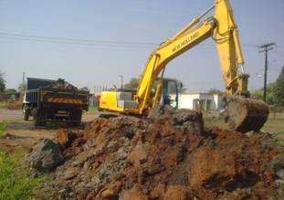 Excavator loading spoil material on a tipper truck in Block F, Soshanguve