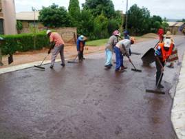 Slurry sealing of road using labour intensive methods in Block H, Soshanguve